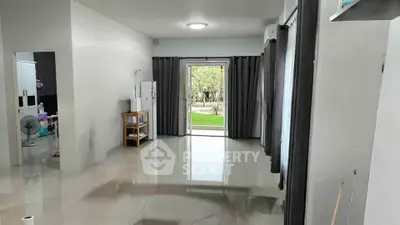 Spacious living room with glossy tiles and garden view through sliding doors.