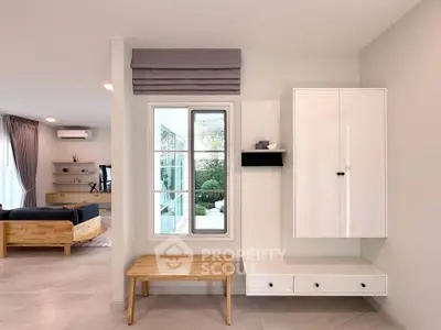 Modern living room with stylish furniture and large window overlooking garden