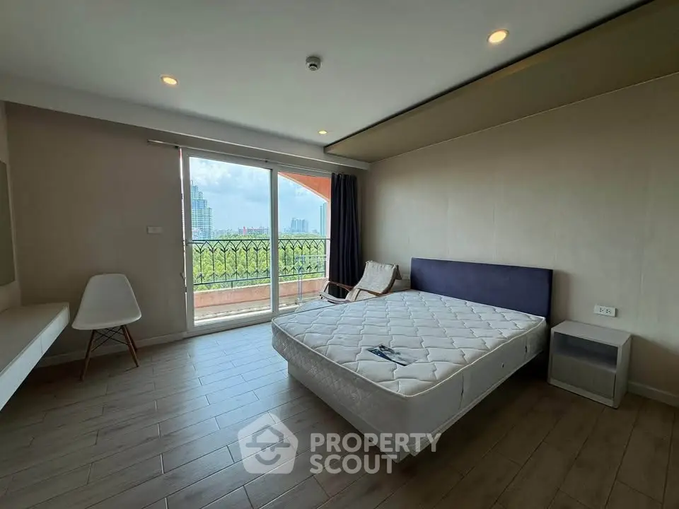 Spacious bedroom with balcony view in modern apartment