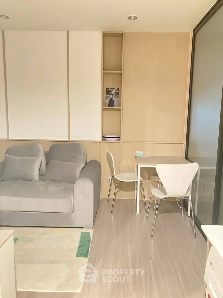 Modern living room with cozy sofa and stylish dining area in a compact space.