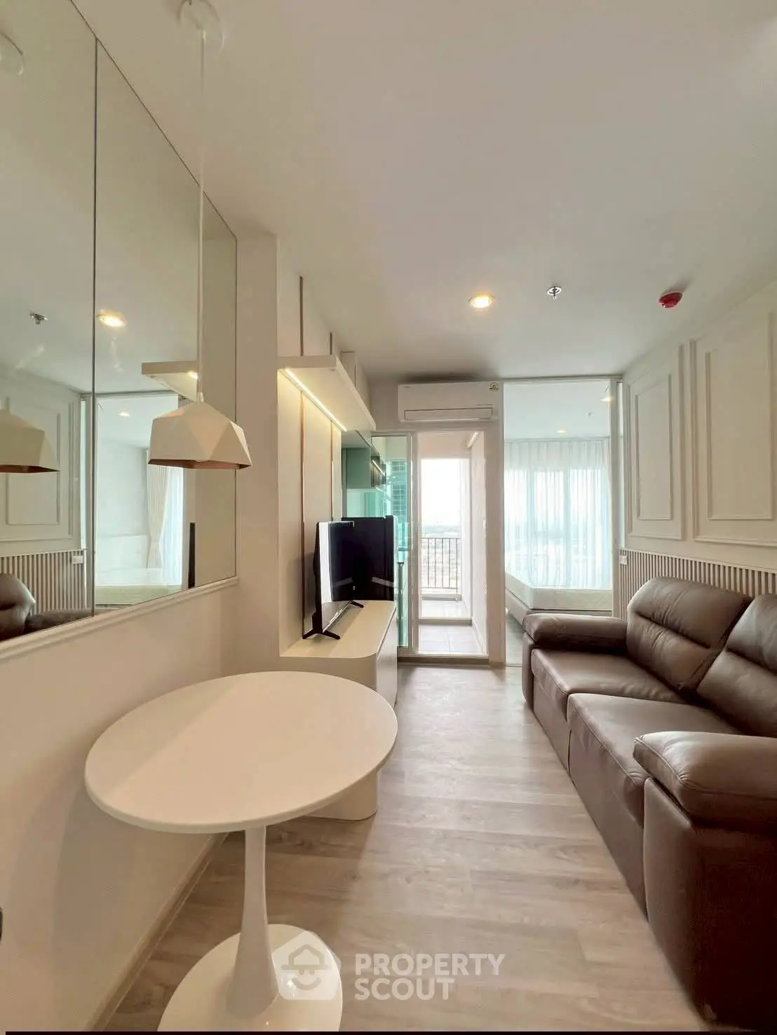 Modern living room with sleek furniture and balcony view in a stylish apartment.