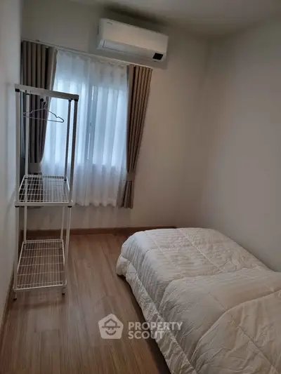 Cozy minimalist bedroom with air conditioning and natural light