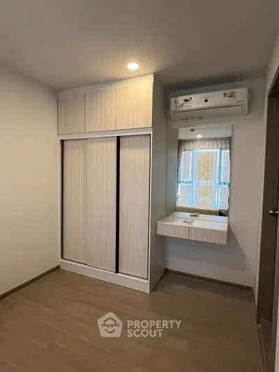 Modern bedroom with built-in wardrobe and air conditioning unit
