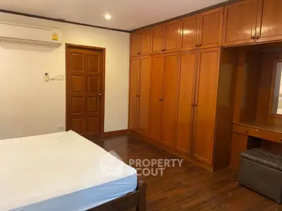 Spacious bedroom with wooden built-in wardrobes and air conditioning