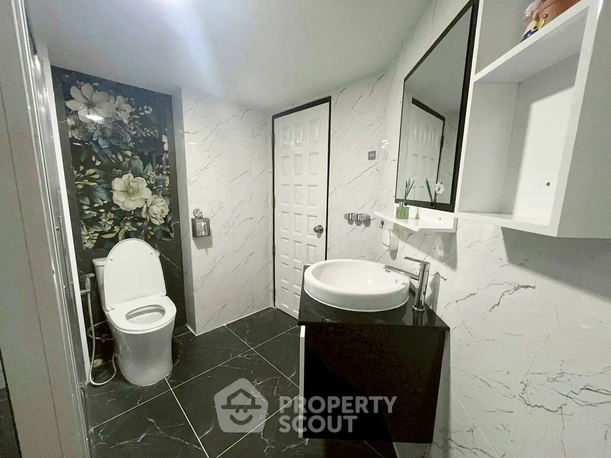 Modern bathroom with floral accent wall and sleek fixtures