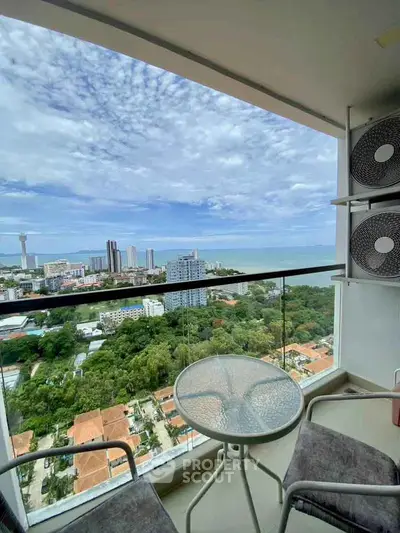 Stunning high-rise balcony with panoramic ocean and city views, perfect for relaxation.