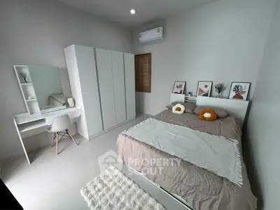 Modern bedroom with stylish decor, featuring a cozy bed, sleek wardrobe, and elegant vanity set.