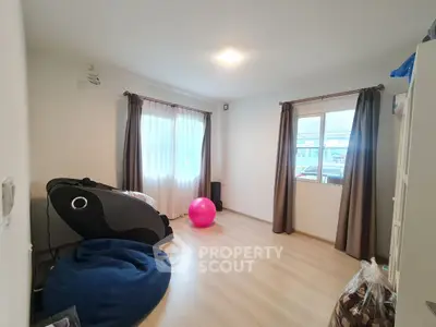 Spacious room with modern decor and natural light, perfect for versatile living or home office setup.