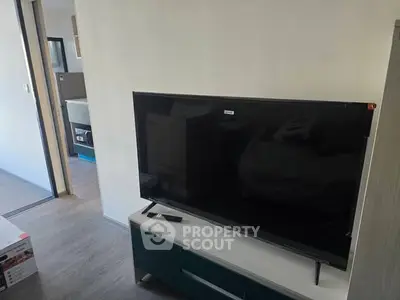 Modern living room with sleek TV and stylish decor in a contemporary apartment.