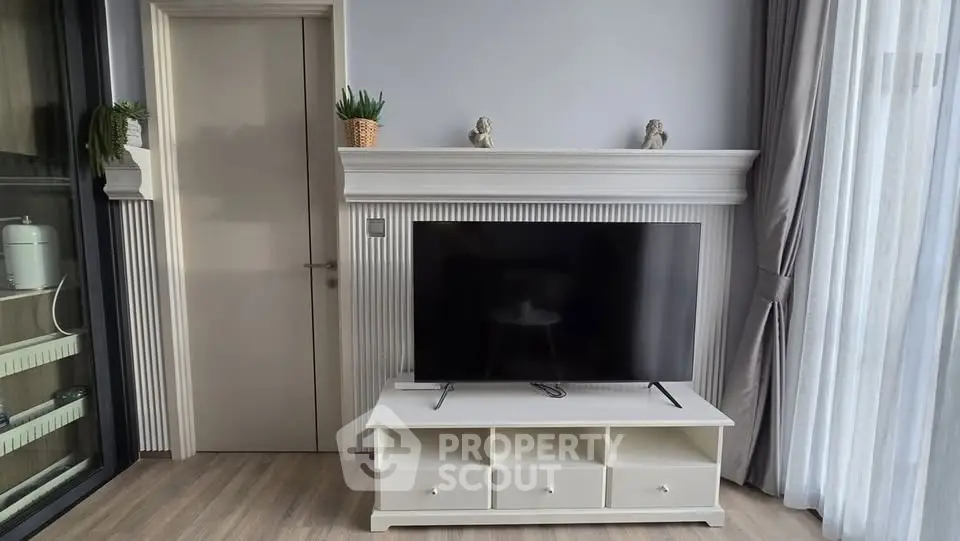 Modern living room with sleek TV stand and elegant decor, featuring natural light and stylish furnishings.
