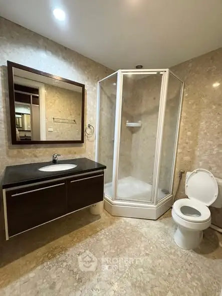 Spacious modern bathroom with elegant fixtures and a sleek shower enclosure.
