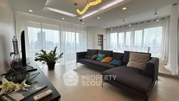 Spacious modern living room with panoramic city views and elegant decor.