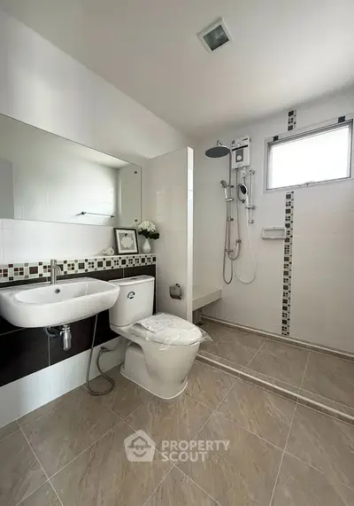 Modern bathroom with sleek fixtures and spacious shower area in a contemporary home.