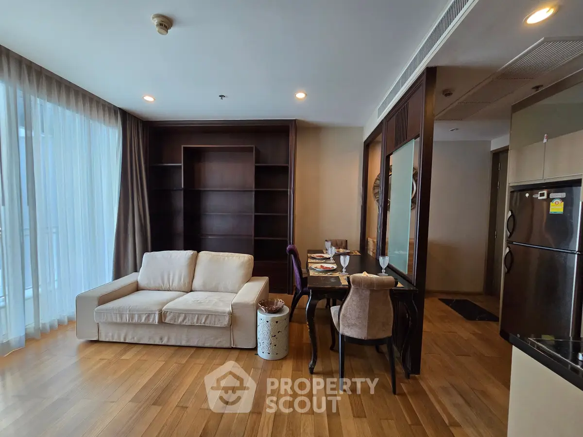 Spacious living room with elegant wooden flooring and cozy sofa, featuring a dining area and modern appliances.