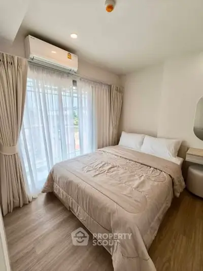 Cozy bedroom with natural light and modern decor, featuring a comfortable bed and elegant curtains.