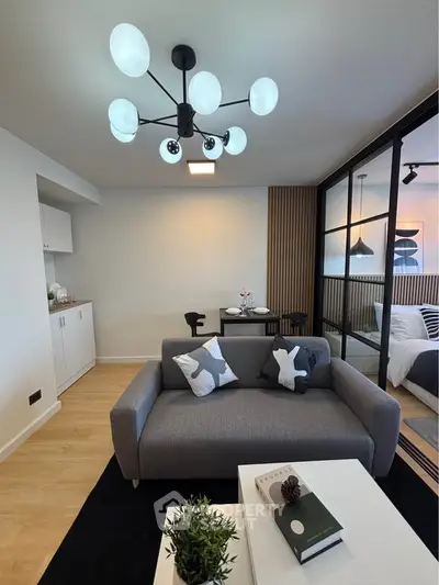 Modern living room with stylish decor and open layout, featuring a cozy sofa and elegant lighting.