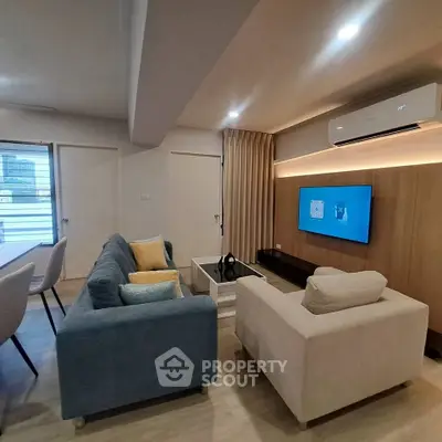 Modern living room with stylish furniture and wall-mounted TV