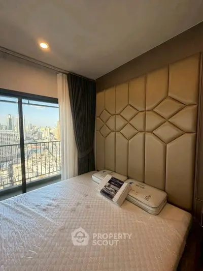 Luxurious bedroom with city view and elegant decor in high-rise apartment.