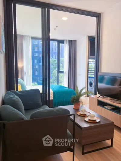 Modern living room with cozy seating and view into stylish bedroom, perfect for urban living.
