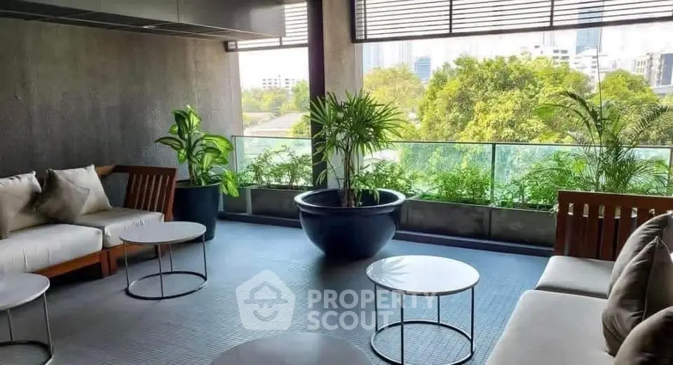 Stylish rooftop lounge with modern seating and lush greenery offering a serene city view.