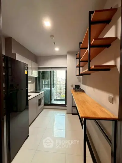 Modern kitchen with sleek appliances and open balcony view