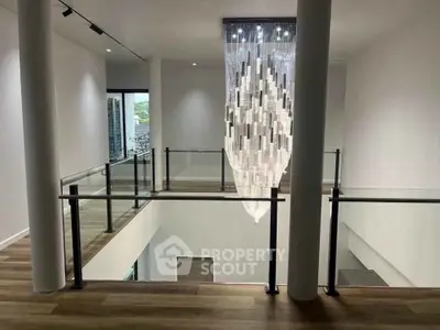 Stunning modern interior with elegant chandelier and glass railing