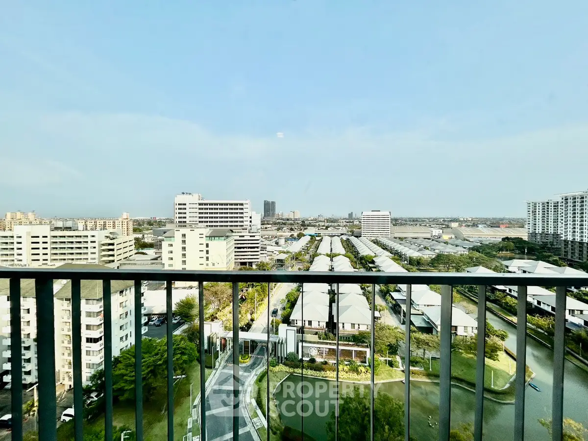 Stunning high-rise balcony view overlooking cityscape and lush greenery.