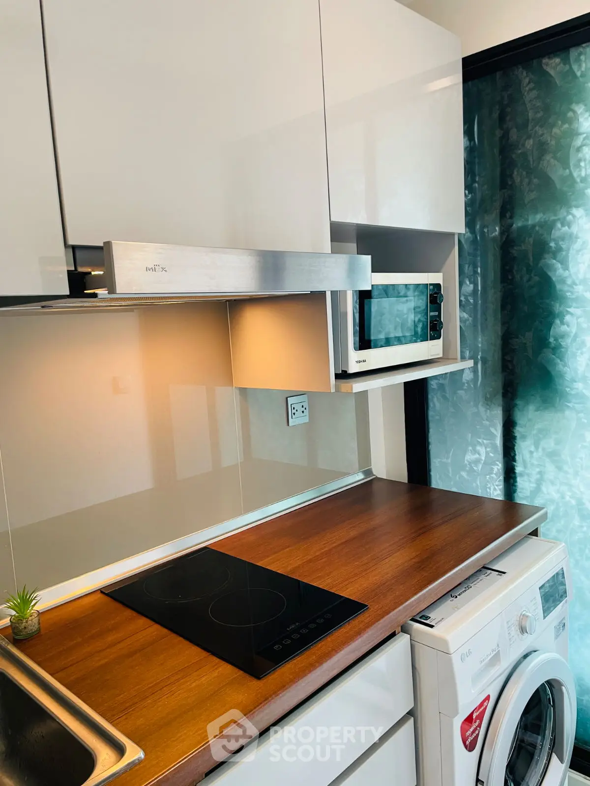 Modern kitchen with sleek appliances and wooden countertop