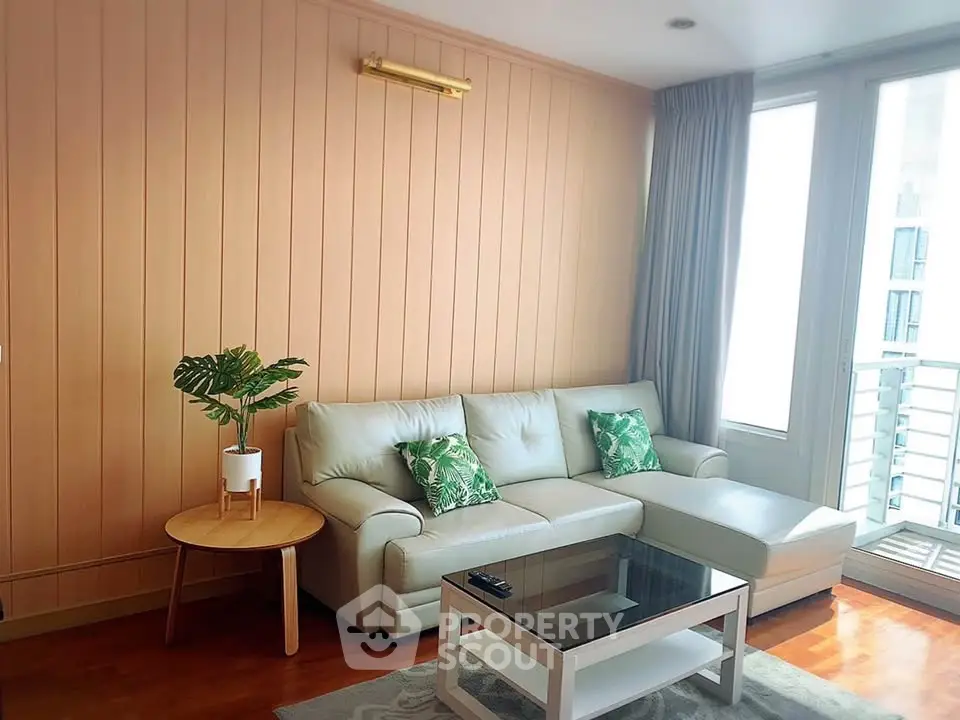 Chic living room with modern sofa, stylish decor, and natural light from large windows.