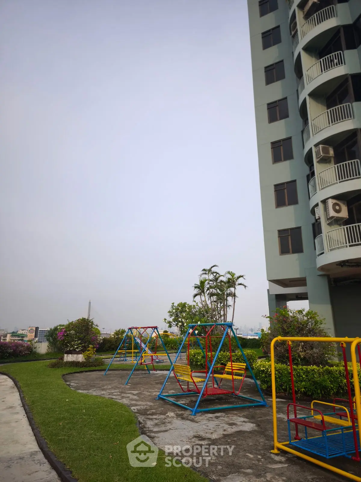 Modern apartment building with playground and lush greenery, perfect for families seeking urban living with outdoor amenities.