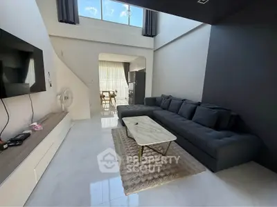 Spacious modern living room with high ceiling and large windows