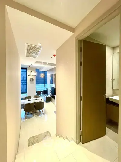 Modern apartment interior with open living and dining area, featuring sleek design and ample natural light.