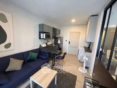 Modern living room with sleek furniture and open kitchen layout in a stylish apartment.