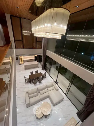 Luxurious modern living room with high ceilings, elegant chandelier, and spacious open layout.