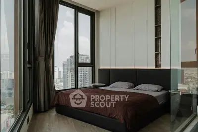 Luxurious bedroom with floor-to-ceiling windows offering stunning city views