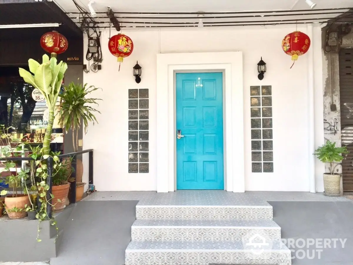 Charming entrance with vibrant blue door and decorative lanterns