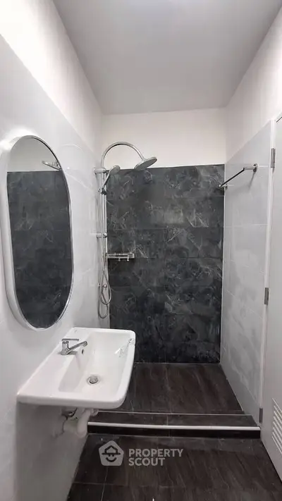 Modern bathroom with sleek shower and elegant sink in minimalist design.