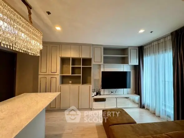 Luxurious living room with elegant chandelier and modern entertainment center