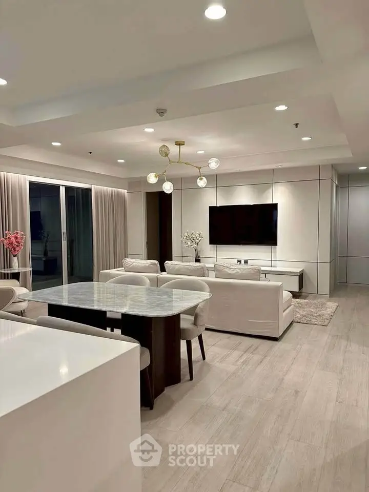 Elegant modern living room with open layout, featuring sleek furniture and ambient lighting.
