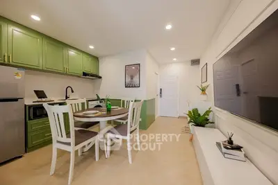 Modern kitchen with green cabinets and dining area in open layout apartment