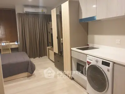 Modern studio apartment with integrated kitchen and cozy sleeping area, featuring sleek design and efficient use of space.