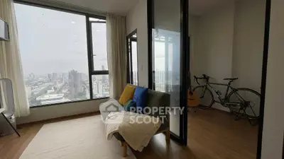 Modern living room with city view, featuring cozy sofa and glass partition, perfect for urban living.