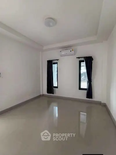 Spacious empty room with air conditioning and large windows, perfect for customization.