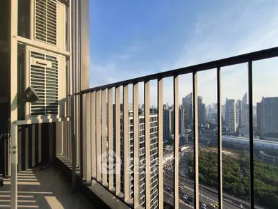 Stunning cityscape view from a high-rise balcony with modern railing design.