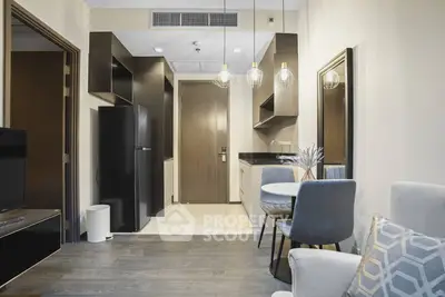 Modern apartment interior with open kitchen and cozy dining area, featuring stylish lighting and contemporary decor.