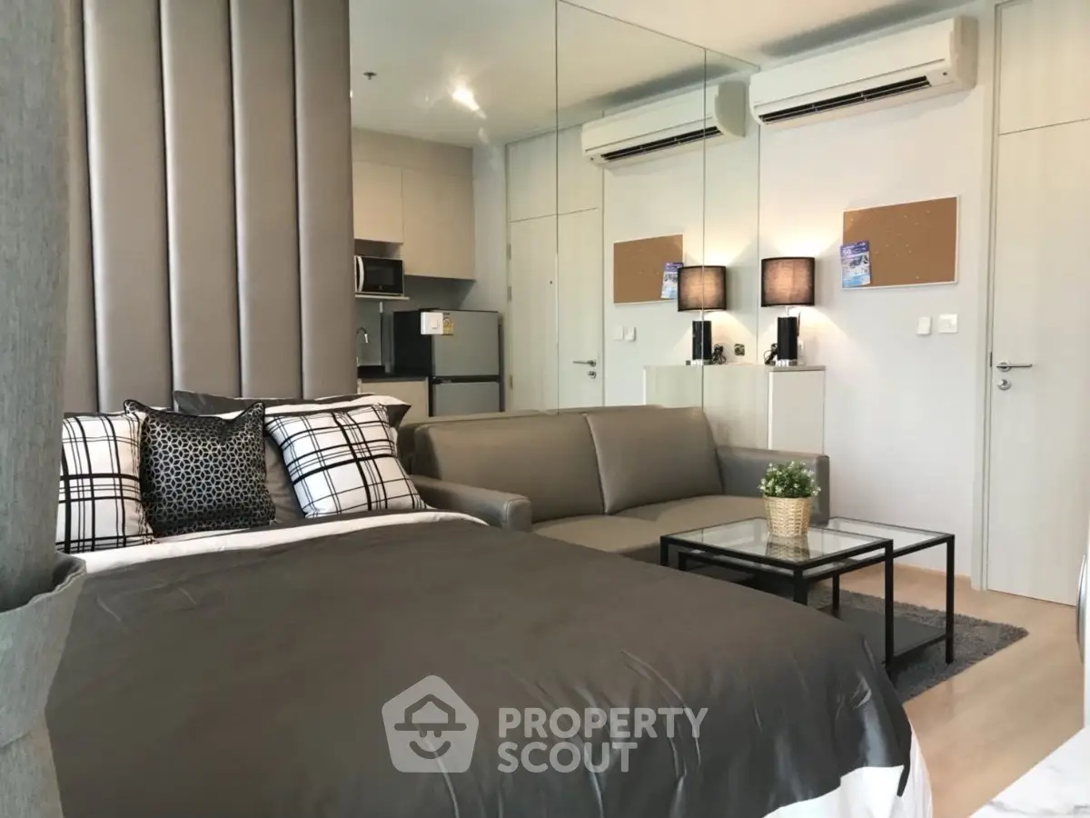 Modern studio apartment with stylish decor and compact kitchen area.