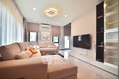 Spacious modern living room with plush sofas and wall-mounted TV, perfect for relaxation.