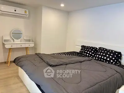 Cozy bedroom with modern decor and stylish vanity in a real estate property.