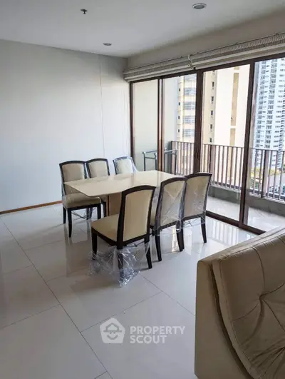 Spacious dining area with modern furniture and large windows offering city views.