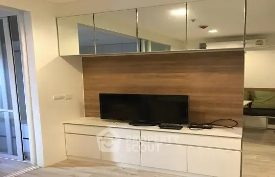 Modern living room with sleek TV unit and mirrored cabinets